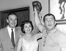  Star Lee Bowman en pretty Jil Jarmyn raise Rocky Graziano's mitt in victory as his pugilistic prowess convinces some dirty gamblers to return the jewels they conned out of a wealthy matron in the episode "Triple Cross" on "Miami Undercover", March 8. 1961