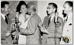 New Wrinkle in commercial programs is this two play mike setup - NBC at left, CBS at right. Event occurred in NBC studios, Radio City, in presentation of the "Edgars" for best radio mystery program to the winners, "Ellery Queen" (CBS) and "Mr. & Mrs. North" (NBC). Left to right: Joe Curtin (Mr. North); Alice Frost (Mrs. North); Ellery Queen (face lost in embrace); Howard Haycraft; Santos Ortega (Inspector Queen). "Edgars" are awarded by Mystery Writers of America, the name honoring Edgar Alan Poe (July 1946).
