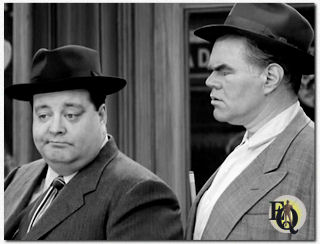 Tegenover Jackie Gleason (L) misschien wel George Mathews (R) én van zijn meest memorabele rollen was die van Harvey in "The Bensonhurst Bomber" een aflevering van de TV-reeks "The Honeymooners". (1956).  Klik op de foto om de clip uit de reeks te zien...