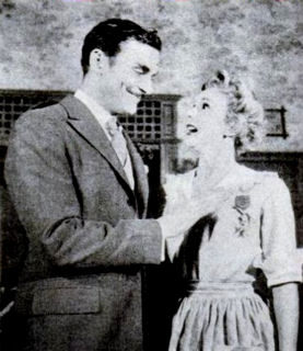 Richard Hart and Eva Gabor in "The Happy Time": A love tap is administered by Uncle Desmonde as he pins one of his numerous medals on pretty Mignonette, a vaudeville acrobat turned maid, whose charms begin to affect him...