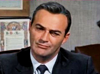 As US Intelligence Agency Official (uncredited) in Hitchcock's "North by Northwest" (1957), Dobkin discusses the plight of the hero, who has been mistaken for an agent who doesn't exist and has now become a murder suspect. "It's so horribly sad," he says drily, "why is it I feel like laughing?" 