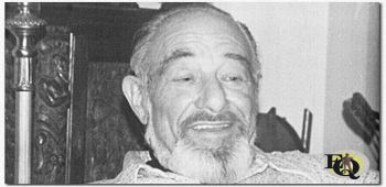 A photograph of an older, bearded Reed sitting on a sofa. He is much slimmer than in previous photos, this plus the beard indicates that the photo was taken sometime late in Reed's life. (c) Alan Reed Collection [digital resource], Pepperdine University Special Collections and University Archives (Used by permission) 